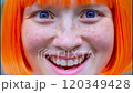 Close up of a woman with bright orange hair and freckles showing a range of facial expressions, from surprise to joy and laughter 120349428