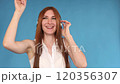 Jovial young woman dancing while listening to 120356307