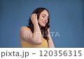 Jovial young woman dancing while listening to 120356315