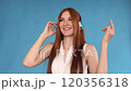 Jovial young woman dancing while listening to 120356318