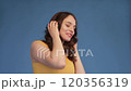 Jovial young woman dancing while listening to 120356319