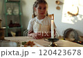 Adorable child blows out a candle, filling the air with a sense of wonder and tranquility. Christmas mood at home 120423678