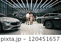 Couple buying new car in car dealership. Premium class car showroom. Husband and wife buy an expensive car. 3d visualization 120451657