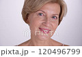 A portrait of a mature woman smiling confidently at camera. Beautiful blond female aging gracefully, using modern anti-aging skincare. 4k 120496799