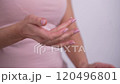 Mature female's hands applying hand moisturizing beauty product. Skincare rituals for aging skin. Self-care and wellness. Faceless 4k 120496801