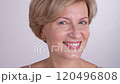 Blond mature woman plays with a cotton pad while posing for a portrait. Modern skincare practices for wrinkle prevention and natural beauty 120496808