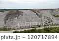 A sobering aerial view of a landfill, highlighting the environmental impact of waste disposal. The image depicts a large mound of garbage, surrounded by natural landscape. 120717894