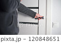 Hand opening a white modern door in a contemporary house, representing entering, leaving, or transition 120848651