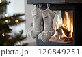 Christmas interior stockings hanging on fireplace with blurred fir tree and presents in background 120849251