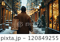 Man walking down snowy street carrying shopping bags during christmas time 120849255