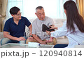 Senior Asian man having an annual health check by doctor. A female doctor comes to see a senior adult patient at home and checks his heart health and blood pressure. Doctor visiting elder patient's ho 120940814
