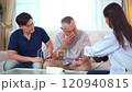 Senior Asian man having an annual health check by doctor. A female doctor comes to see a senior adult patient at home and checks his heart health and blood pressure. Doctor visiting elder patient's ho 120940815