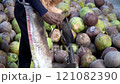 Coconut Cutting with a Traditional Knife: Tropical Market Scene 121082390