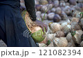 Coconut Cutting with a Traditional Knife: Tropical Market Scene 121082394