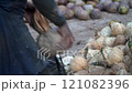Coconut Cutting with a Traditional Knife: Tropical Market Scene 121082396