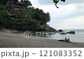 A couple sits on a large rock by the water on a beautiful beach. Haad Sadet Beach, Koh Phangan island, Thailand 121083352