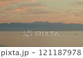 Serene scene of person paddle boarding on a calm sea during sunset 121187978