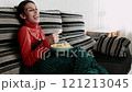 Young woman eating chips while enjoying a movie on laptop. Young hispanic 121213045
