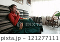 Young woman relaxing and snacking while watching tv on sofa. Young hispanic 121277111