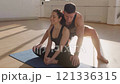 Fitness trainer practicing yoga with a young woman apprentice on yoga mats in the gym in the morning, fitness girl Generation Z and trainer man yoga workout in light fitness room 4K UHD B-Roll footage 121336315