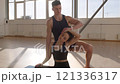 Fitness trainer practicing yoga with a young woman apprentice on yoga mats in the gym in the morning, fitness girl Generation Z and trainer man yoga workout in light fitness room 4K UHD B-Roll footage 121336317