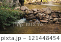 water flows over rocks in a mountain river 121448454