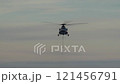 Helicopter is coming with cable for cargo. Rope is attached to bottom of helicopter. Mi-8 helicopter on background of evening sky 121456791