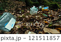 Pile of trash is on the ground in a forest 121511857