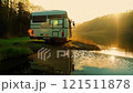 Camper van is parked on the side of a river 121511878