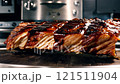 Large rack of ribs is sitting on a wooden cutting board 121511904