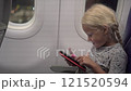 Portrait of child girl on airplane with smartphone 121520594