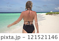 Young attractive woman walking along sandy beach on tropical island on sunny day 121521146