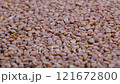 Heap of uncooked dry buckwheat groats. Grechka. Slider shot. Depth of field, selective focus. Texture of grains. Cooking, whole grains, traditional cuisine, food related concepts. 4k 121672800