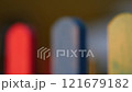 The colorful painted wooden boards on the fence around a playground are illuminated by the rays of the setting sun. Pula, Croatia - January 3, 2025 121679182