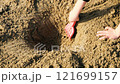 Close up hands of baby boy toddler playing on sand, and digging on the beach. 121699157