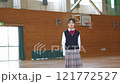 A female student standing and smiling in a gym 121772527