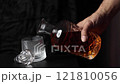 The wonderful moment of Pouring whiskey from The crystal decanter in to a glass on dark background. 121810056