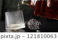 The wonderful moment of Pouring whiskey from The crystal decanter in to a glass on dark background. 121810063
