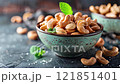 Roasted salted cashew nuts in clay plate. 121851401