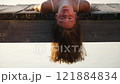 Woman Resting Upside Down on Pier Edge 121884834
