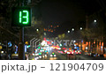 Time Lapse video. Traffic light with green countdown timer against the backdrop of a night city. Blurred moving car lights and street lighting create a dynamic atmosphere 121904709