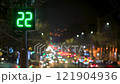 Traffic light with green countdown timer against the backdrop of a night city. Blurred moving car lights and street lighting create a dynamic atmosphere 121904936