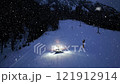 Aerial view of snowcat. Snowy alpine ski slope at night. Snowfall 121912914