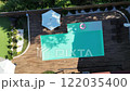 Aerial view of a serene modern backyard pool with a wooden deck and a pink inflatable 122035400