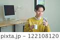 Young man sitting on a sofa and using a smartphone 122108120