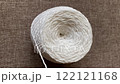 White thread unwinds from a ball, top view and selective focus. Needlework concept 122121168