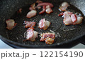 Cooking bacon and eggs in a frying pan 122154190