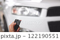 Footage Close up, A Woman holding keys to press car door unlock button against white car background with flashing orange lights. VDO 4K resolution. concept of Vehicles, Travel, Safety, and Driving. 122190551