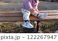 公園のベンチに座り降りる女の子の子供 122267947