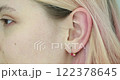 Ear piercing with colorful jewelry in a beauty studio 122378645